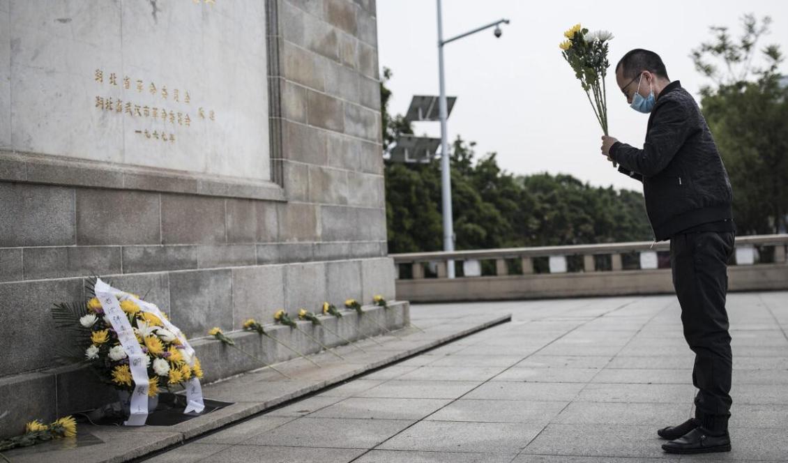 En kinesisk man i Wuhan lämnar blommor för att hedra alla de offer som dött till följd av virusutbrottet i Wuhan och Kina. Wuhan, Kina den 4 april 2020. Foto: Getty Images