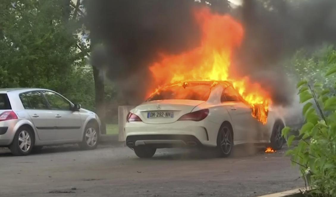 En tv-bild visar en bil i lågor under upploppen i franska Dijon. Foto: BFM TV/AP/TT