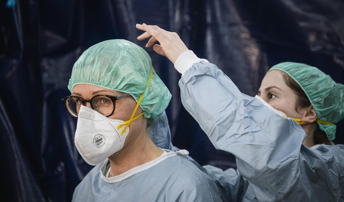 
En sjuksköterska och en läkare tar på sig skyddsutrustning i ett tält vid Sophiahemmet i Stockholm innan man genomför covid-19-tester på patienter. Foto: Jonathan Nackstrand/AFP via Getty Images                                            