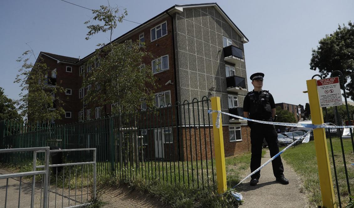
En polis bevakar ingången till en fastighet där en lägenhet söktes igenom efter dådet i brittiska Reading den 20 juni. Foto: Matt Dunham/AP/TT-arkivbild                                            