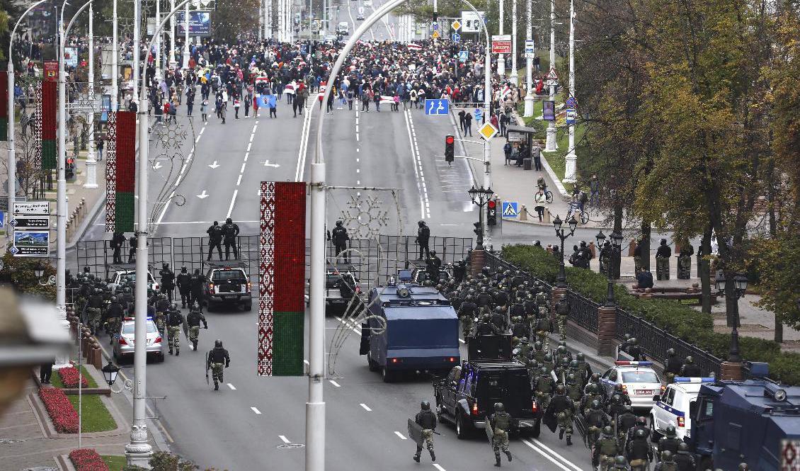 Säkerhetsstyrkor och demonstranter på gatorna i Minsk på söndagen. Foto: AP/TT