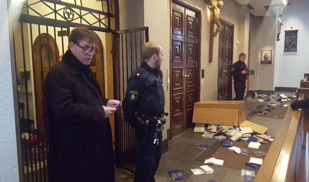 Kyrkoherde Tobias Unnerstål (tv) i samtal med polisen sedan Katolska kyrkan i Göteborg utsatt för vandalism. Bland annat har psalmböcker vräkts ut över golvet. Foto: Max Skalenius