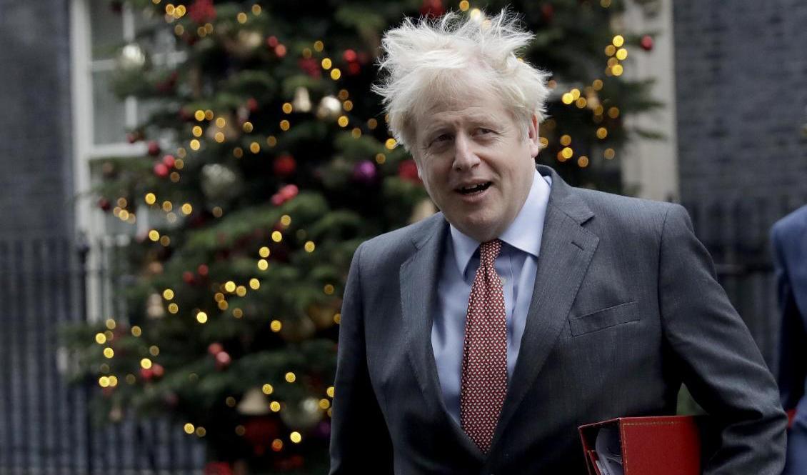 Storbritanniens premiärminister Boris Johnson passerar förbi julgranen på 10 Downing Street i London. Foto: Matt Dunham/AP/TT