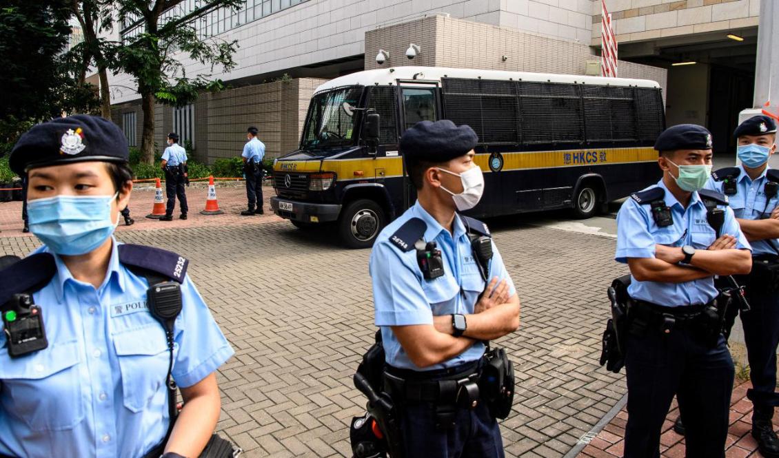 Poliser kantar en gata medan den tonåriga demokratiaktivisten Tony Chung i Hongkong förs bort med bil 29 oktober, efter anklagelser om brott mot säkerhetslagen. Foto: Anthony Wallace/AFP via Getty Images.