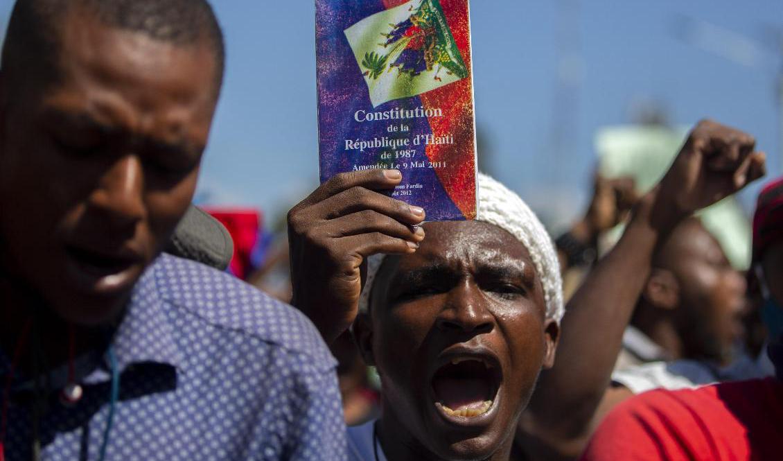 En demonstrant viftar med Haitis konstitution under protester i Port-au-Princes tidigare i veckan. Foto: Dieu Nalio Chery/AP/TT