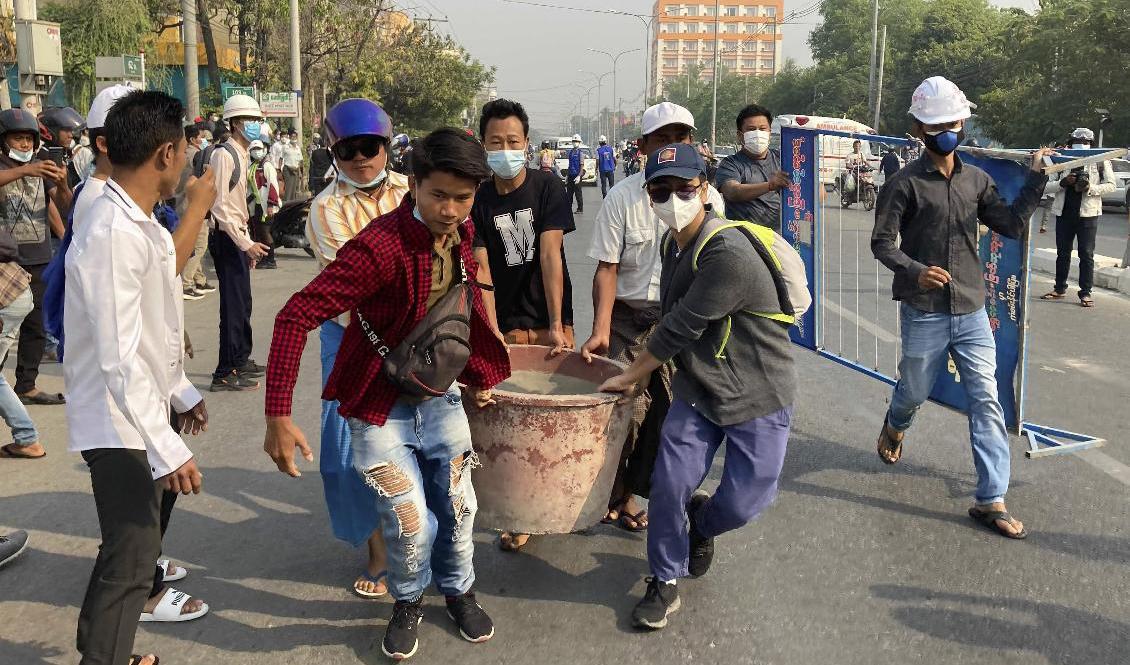 Demonstranter blockerar en väg i Mandalay på söndagen. Foto: AP/TT