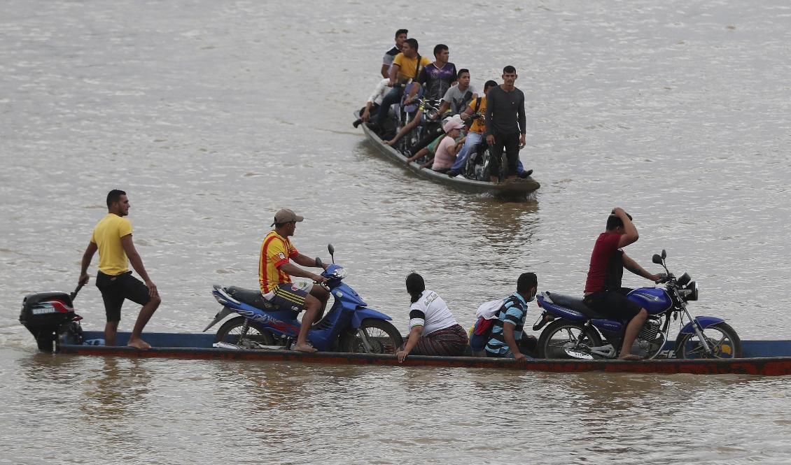 Venezuelaner flyr över floden Arauca, den naturliga gränsen mot Colombia, efter våldsamheter i veckan mellan militär och gerilla. Foto: Fernando Vergara/AP/TT