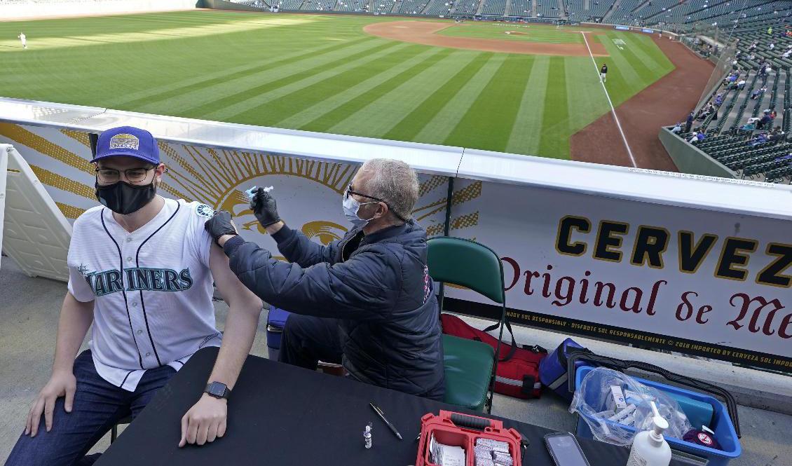 Den avtagande vaccinationstakten i USA oroar, men här får Seattle Mariners-supportern Hunter Moreira sitt covidvaccin före basebollmatchen mot Baltimore Orioles. Foto: Ted S Warren/AP/TT