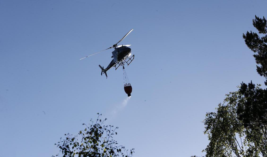 Helikopter som vattenbombar branden i Vrinneviskogen. Foto: Magnus Andersson/TT
