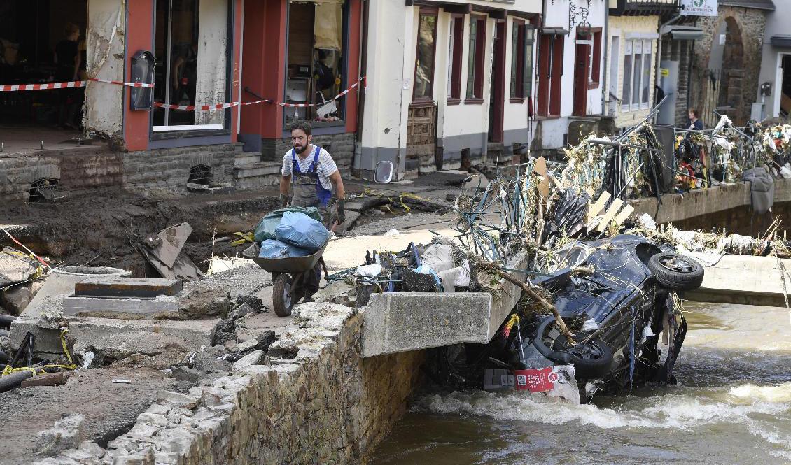 En man bär undan bråte i Bad Münstereifel. Foto: Roberto Pfeil/AP/TT