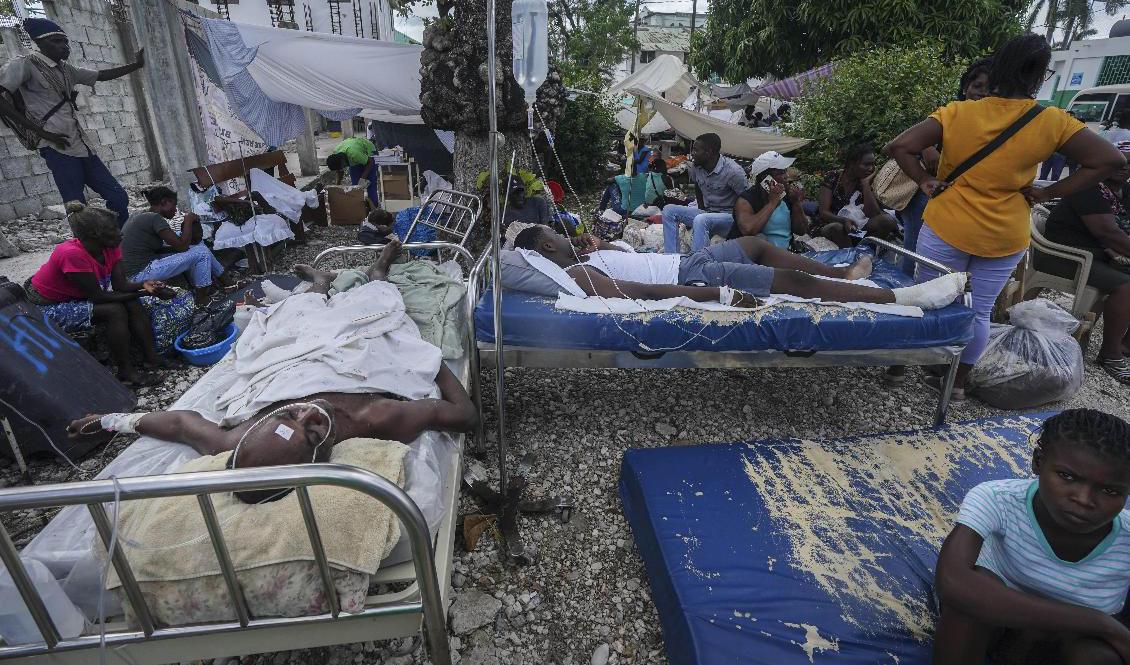Skadade efter lördagens jordskalv vårdas utomhus i Les Cayes. Foto: Fernando Llano/AP/TT