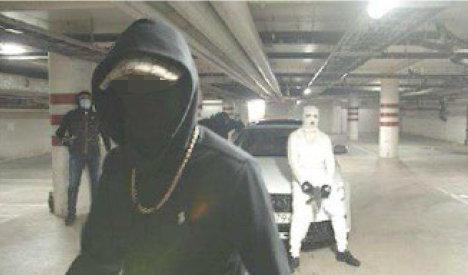 Bild från inspelningen av rapvideon. Den vita Audin är samma bil som användes vid skottlossningen vid en snabbmatsrestaurang i Botkyrka en tid senare, där en tolvårig flicka dödades. Foto: Polisen