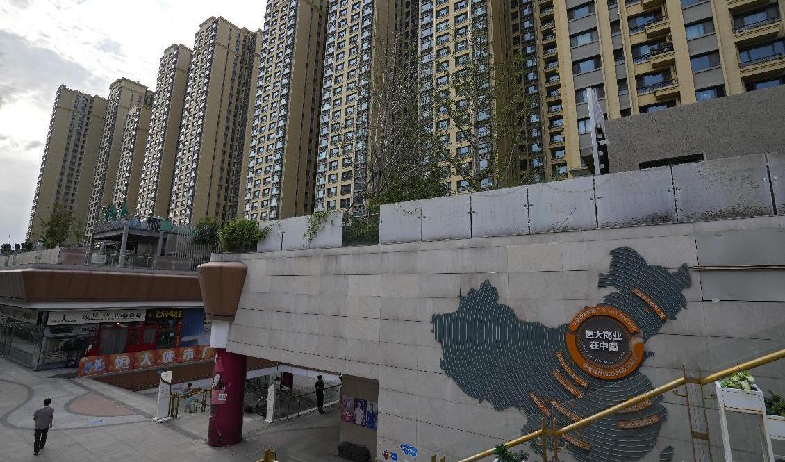 En karta över krisdrabbade Evergrandes fastighetsutvecklingsprojekt syns på en husfasad i ett köpcentrum i Peking med ett av koncernens bostadskomplex i bakgrunden. Foto: Andy Wong/AP/TT