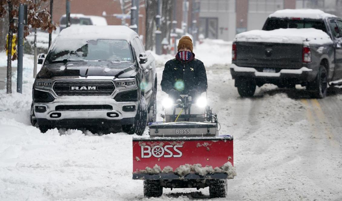 En man kommer farande med en snöplog i Pittsburgh under måndagen. Foto: Gene J Puskar/AP/TT