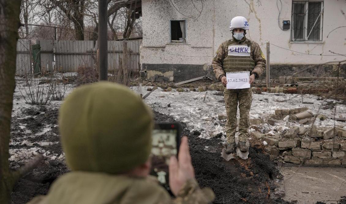 En grop som orsakats av en artillerigranat dokumenteras i samhället Vrubivka i Luhansk under torsdagen. Foto: Vadim Ghirda/AP/TT