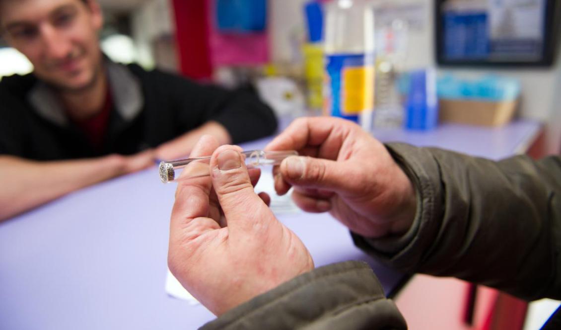 En man håller upp en crackpipa på en buss vid stationen Gare du Nord i Paris, 29 april 2013. Foto: Lionel Bonaventure/AFP via Getty Images
