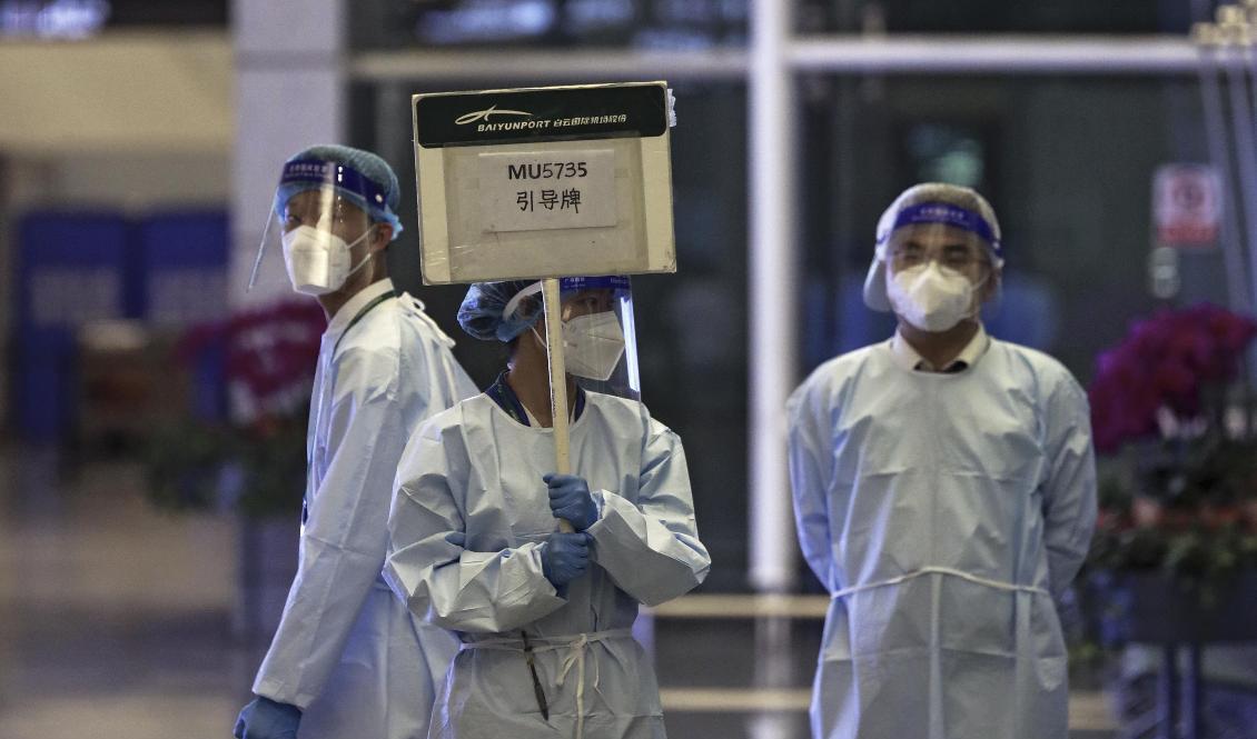 Medarbetare hos China Eastern håller upp en skylt för att möta anhöriga till människor som var ombord på olycksplanet, på en flygplats i Kanton. Foto: Chinatopix via AP/TT