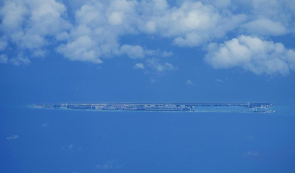 Kinesiska byggnader syns på en konstgjord ö – av USA kallad Fiery Cross Reef – vid Spratlyöarna i Sydkinesiska sjön. Foto: Aaron Favila/AP/TT