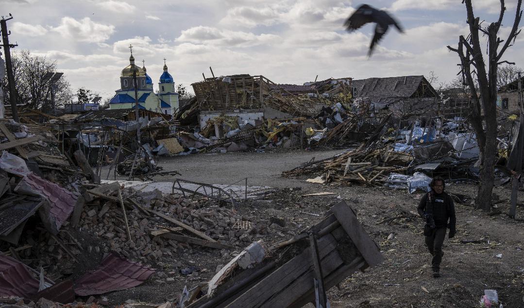 En journalist vandrar genom förödelsen efter en rysk attack i Byshiv i utkanten av huvudstaden Kiev. Foto: Rodrigo Abd/AP/TT