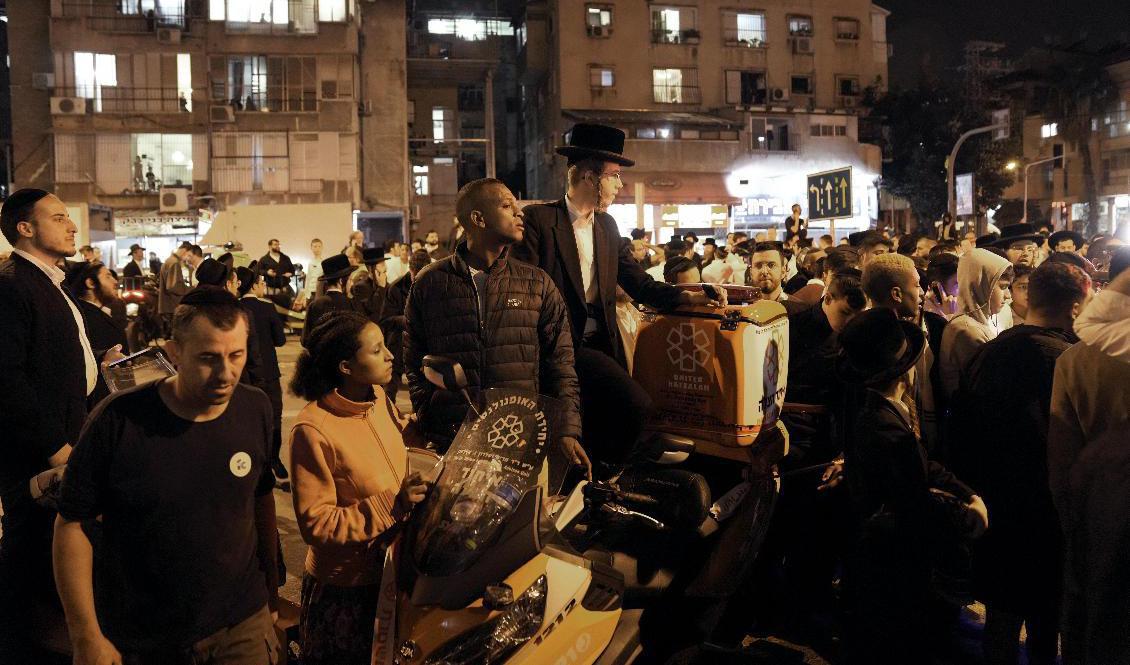 Människor samlas vid platsen för en attack i den israeliska staden Bnei Brak nära Tel Aviv i israel på tisdagskvällen. Minst fem människor rapporteras ha mist livet i attacken. Foto: Oded Balilty/AP/TT