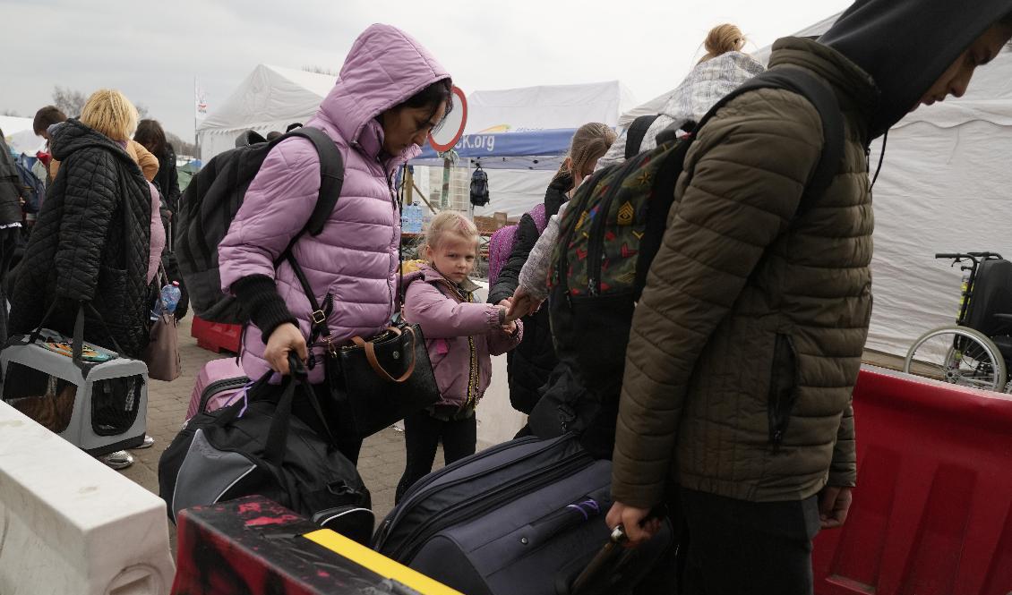 Människor på flykt från Ukraina korsar gränsen till Polen vid Medyka den 29 mars. Foto: Sergei Grits/AP/TT