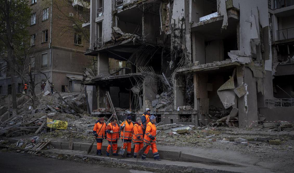 Kiev anfölls på nytt av robotar under torsdagskvällen. Här går människor runt och städar bland rasmassorna. Foto: Emilio Morenatti/AP/TT