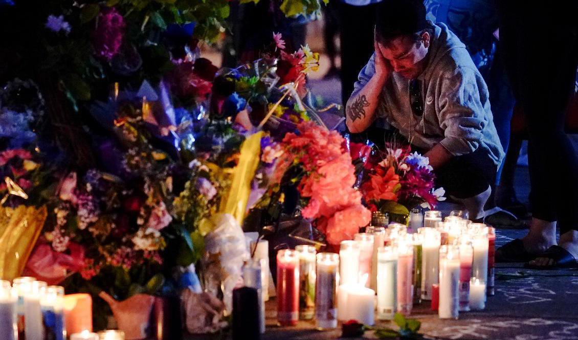 Människor samlas utanför matbutiken där skjutningen inträffade. Foto: Matt Rourke/AP/TT