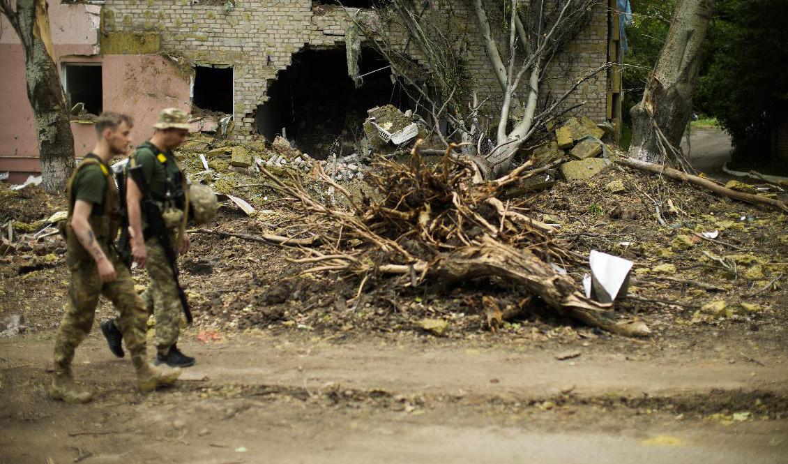 Ukrainska soldater passerar en sönderbombad byggnad i Bachmut i den nordliga delen av Donetsk i slutet av maj. Arkivbild. Foto: Francisco Seco/AP/TT