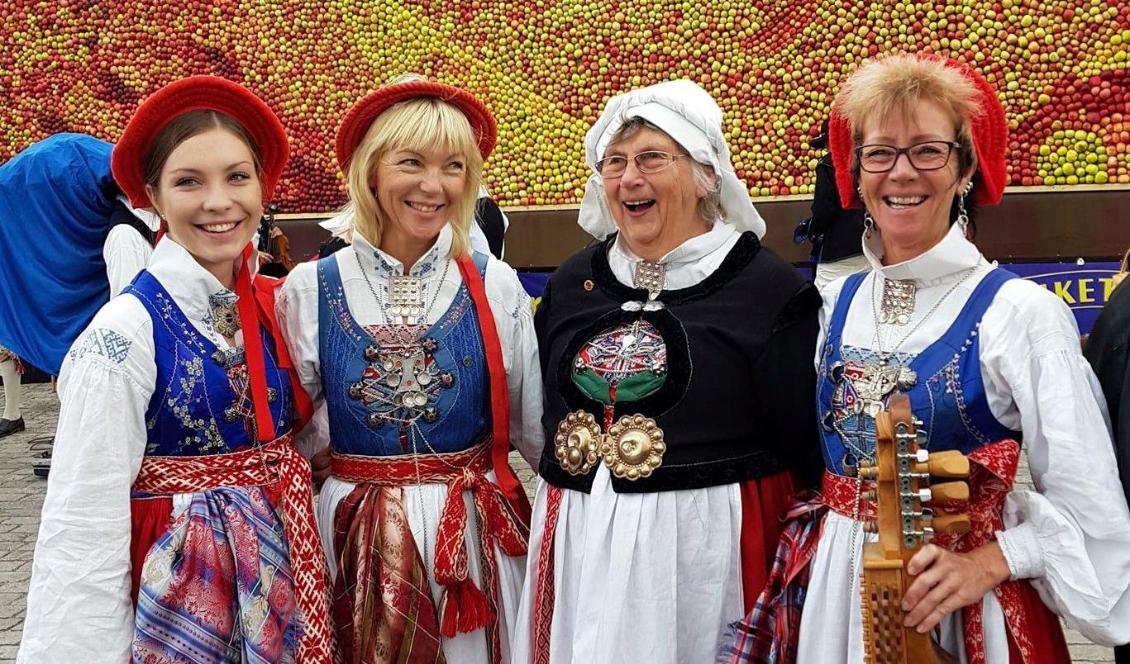 Tre generationer bär Ingelsta härads festdräkt: Ann-Margret Malmqvist (tredje från vänster) i vit klut, och barn och barnbarn med lock (huvudbonad) med hängande band. Foto: Privat