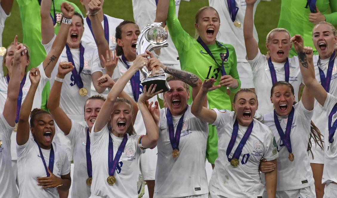 Englands lagkapten Leah Williamson, till vänster med pokalen, och mittbackskollegan Millie Bright, till höger med pokalen, EM-guldjublade med resten av laget. Foto: Rui Vieira/AP/TT