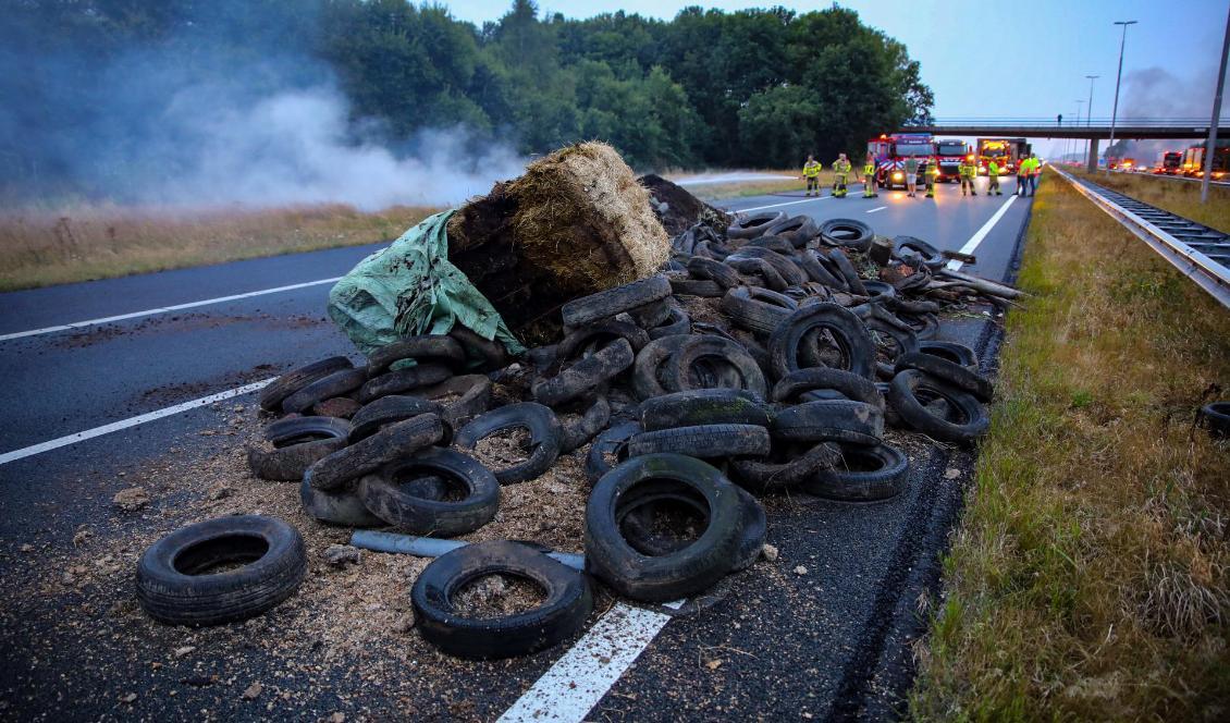


Gödsel, bildäck och höbalar på motorvägen A50 i Apeldoorn i Nederländerna i samband med bondeprotesterna i landet den 27 juli 2022. Foto: ANP/AFP via Getty Images                                                                                                                                    