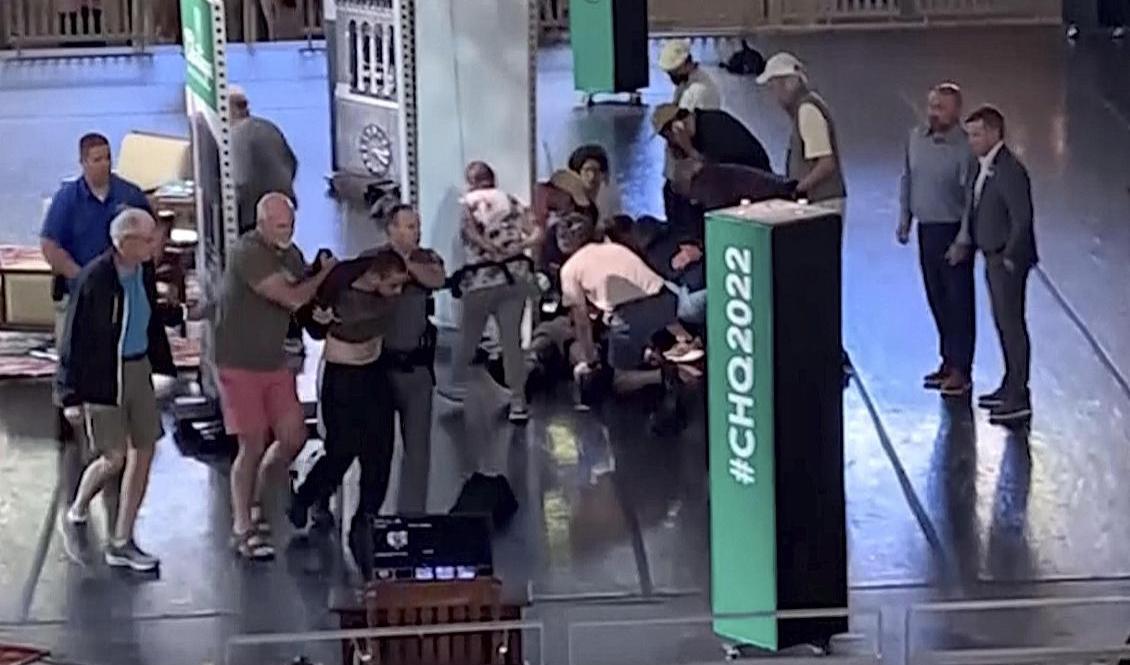 En 24-årig man som misstänks för att ha attackerat Salman Rushdie förs bort, samtidigt som Rushdie tas om hand. Foto: AP/TT