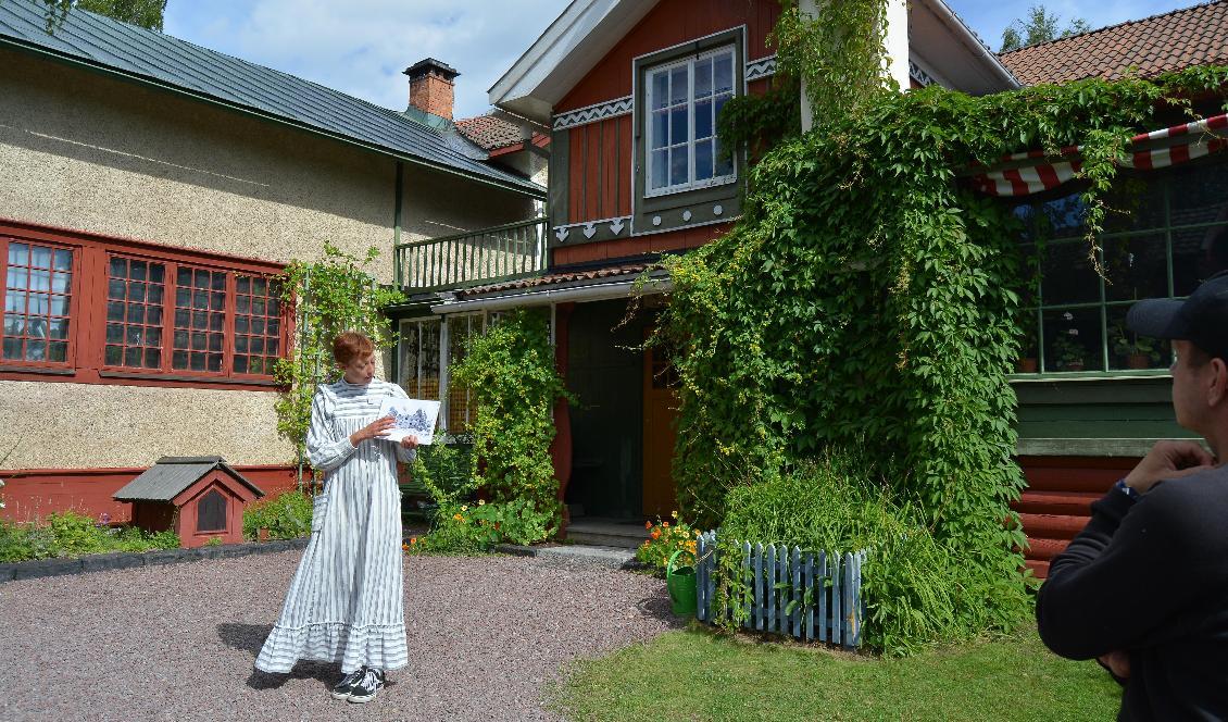 

Guiden Veronica Pedersen i en klänning designad av Karin Larsson, framför paret Larssons hus i Sundborn. Foto: Eva Sagerfors                                                                                        