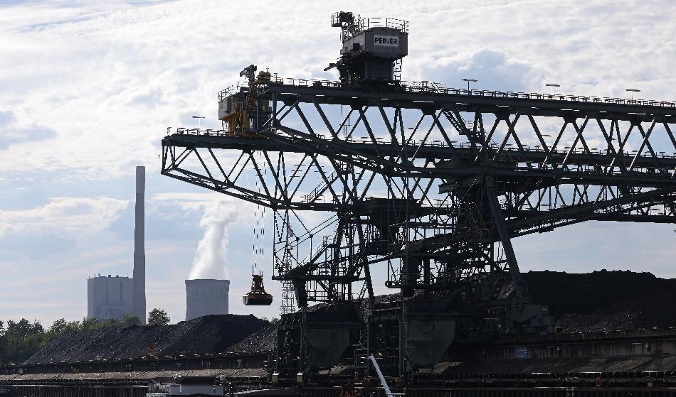 Kol till kolkraftverket Kraftwerk Mehrum lossas från en pråm den 3 augusti nära Peine i Tyskland. Kolkraftverket ses i bakgrunden. Den 31 juli togs det i bruk igen. Foto: Sean Gallup/Getty Images