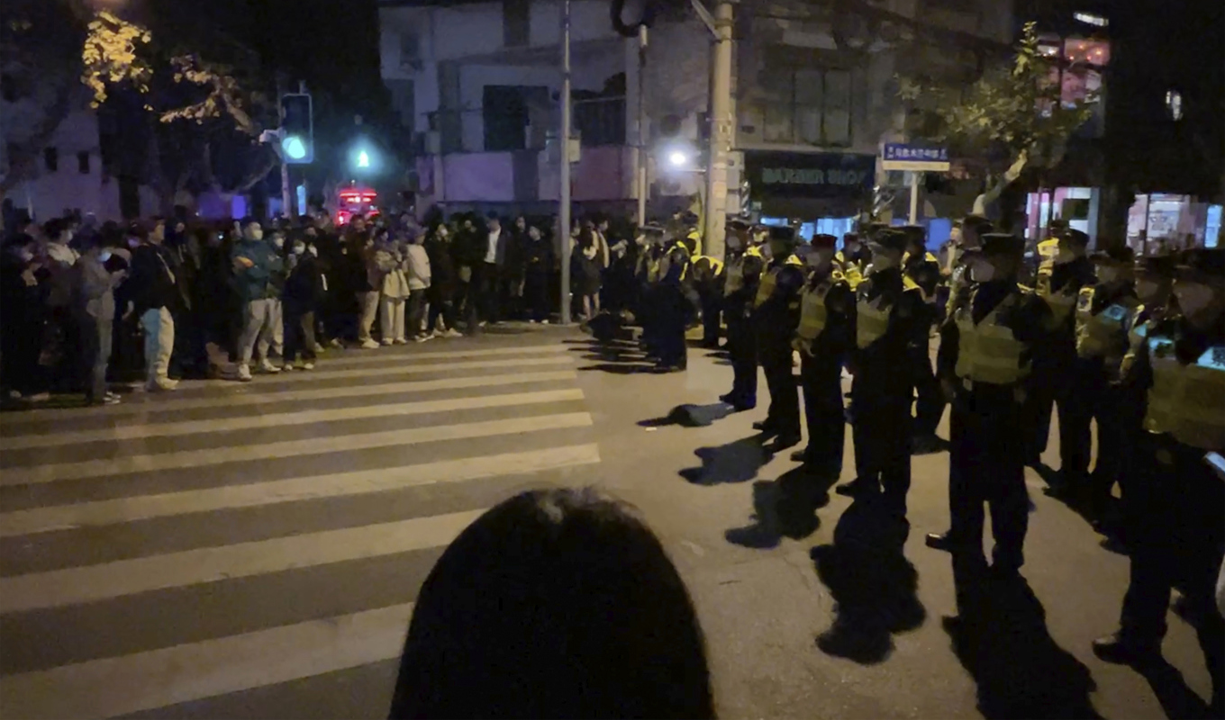 Kinesisk polis blockerar tillgång till delar av den kinesiska staden Shanghai där demonstranter samlades under söndagen. Foto: AP/TT