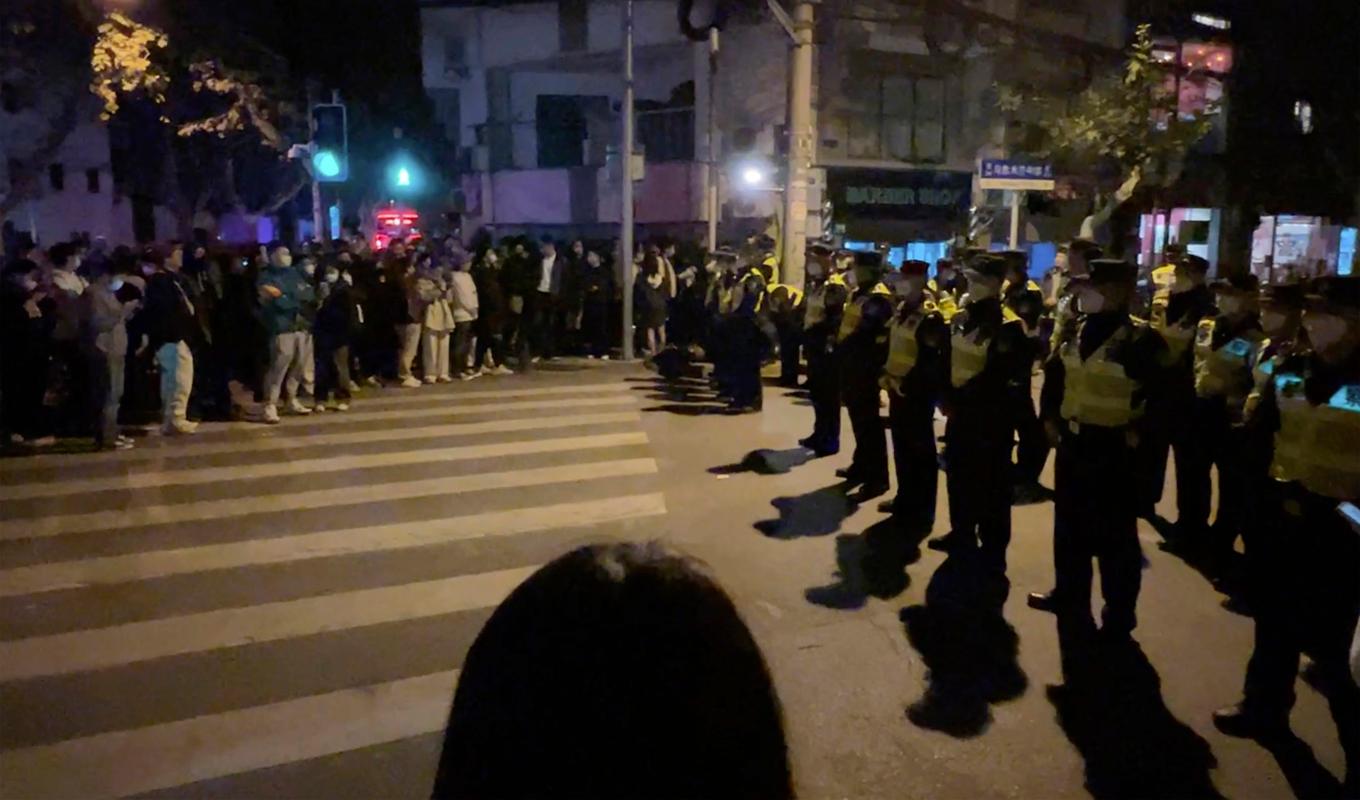 Kinesisk polis blockerar tillgång till delar av den kinesiska staden Shanghai där demonstranter samlades under söndagen. Foto: AP/TT
