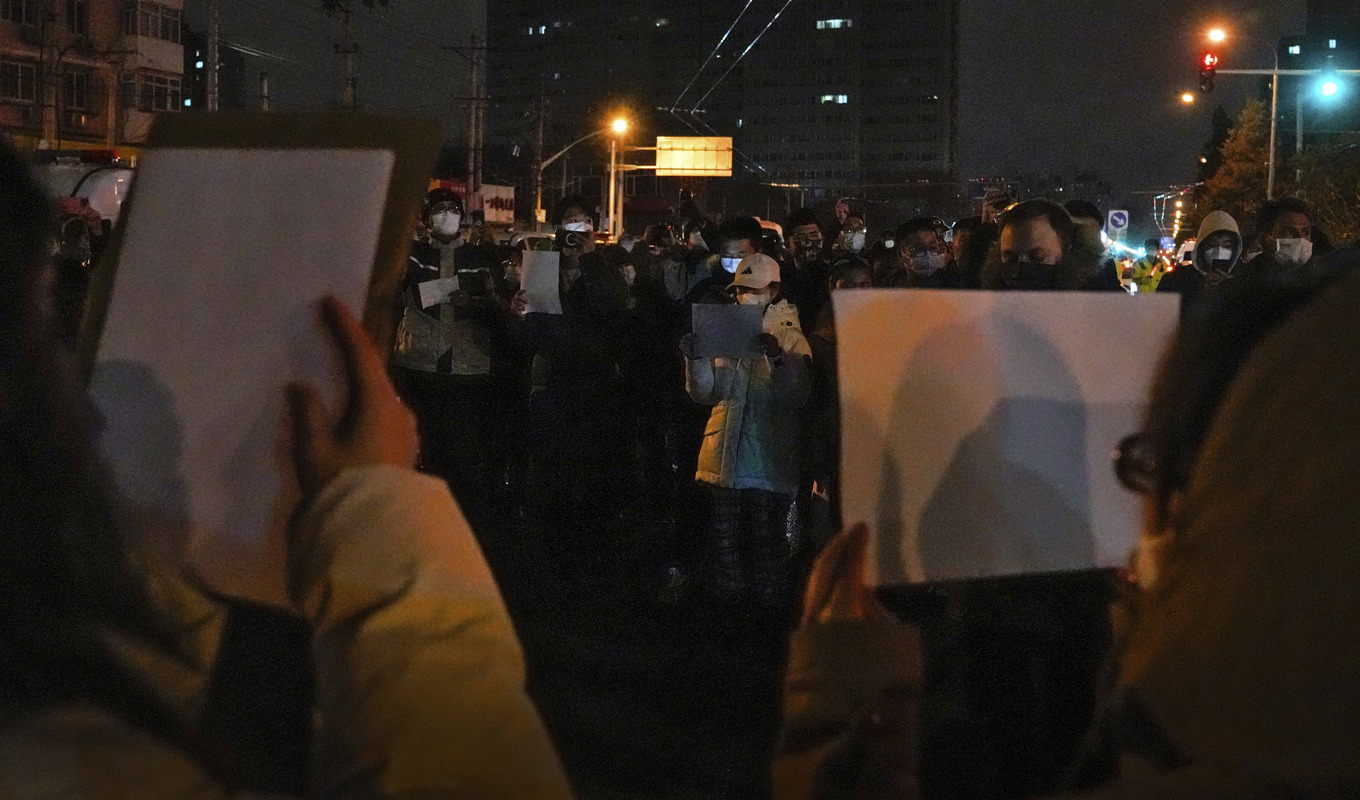 Tomma A4-papper hölls upp vid en demonstration mot covidrestriktionerna i Kina, i huvudstaden Peking i söndags. Foto: Andy Wong/AP/TT
