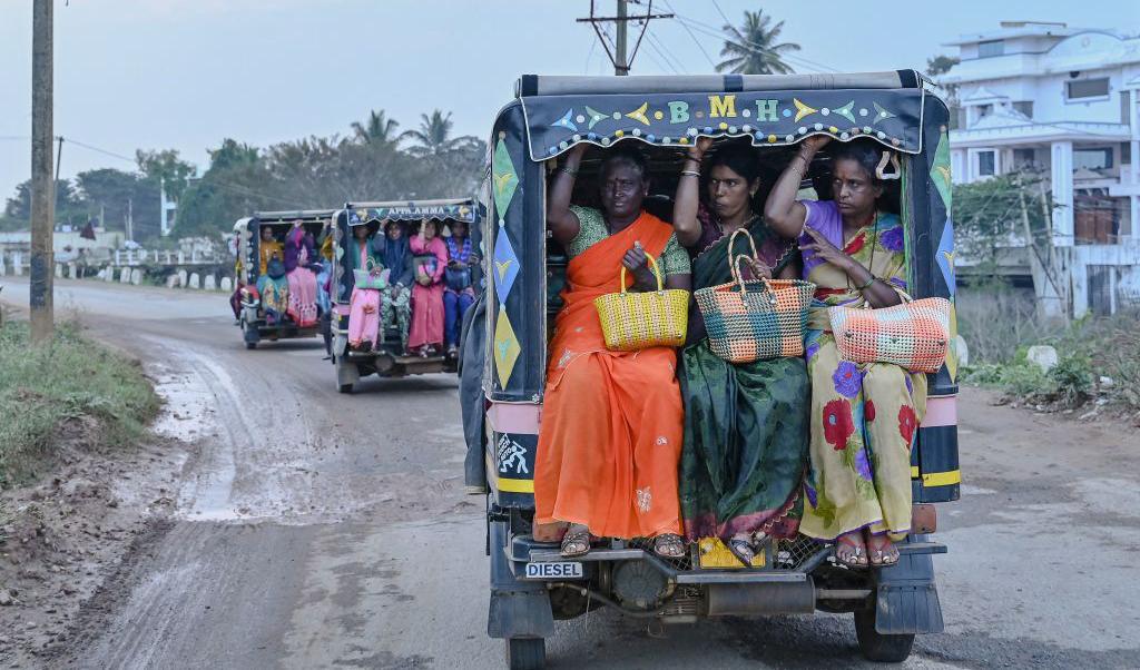 Kvinnor slutar sist arbete för dagen på en farm en bit från staden Bengalore, Indien. För att ta sig hem efter jobbet den 24 november 2022, åker de rickshaw som numera är motoriserade. Foto: Manjunath Kiran/AFP via Getty Images
