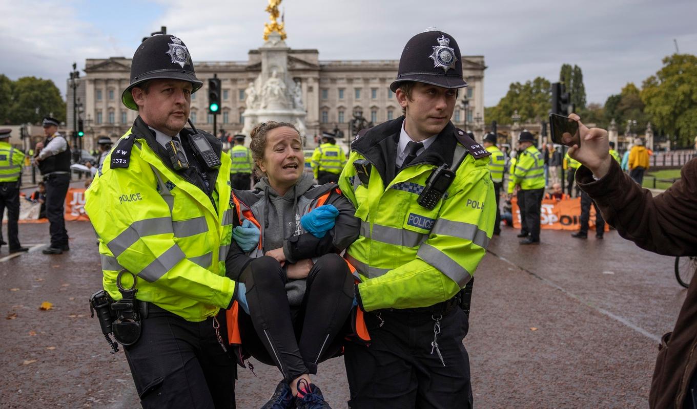 En klimataktivist utanför Buckingham Palace förs iväg av polis den 10 oktober 2022. Foto: Dan Kitwood/Getty Images