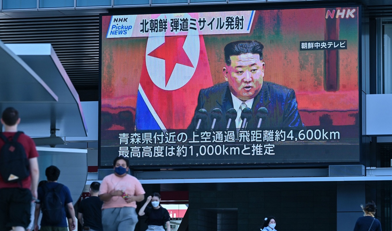 Människor i Tokyo i Japan promenerar vid en tv-skärm som visar bilder på Nordkoreas ledare Kim Jong-Un efter att Nordkorea skjutit upp en missil den 4 oktober. Foto: Richard A. Brooks/AFP via Getty Images