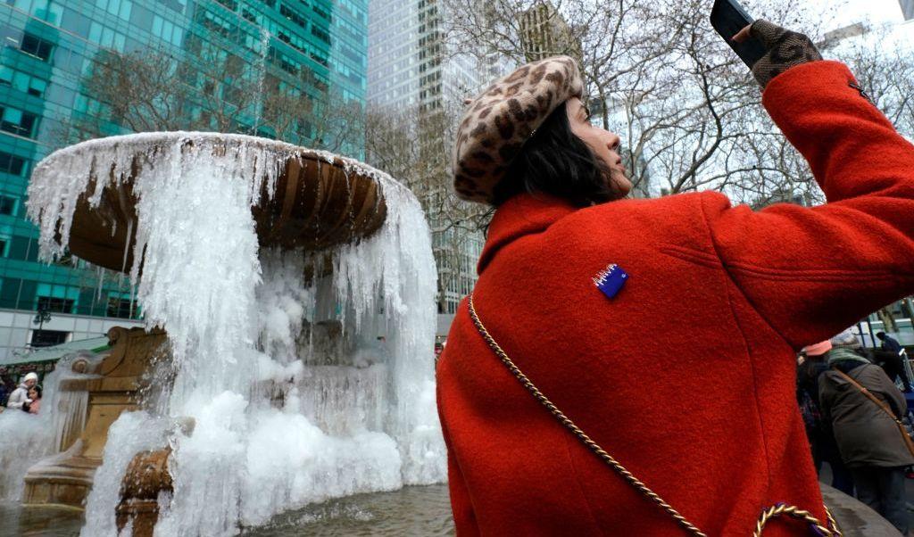 


En kvinna tar bilder vid en fontän i Byrant Park, New York den 27 december. Temperaturerna förväntas stiga under dagen i östra och mellersta USA, efter dagar av iskallt väder från "århundradets storm". Minst 49 döda och julresekaos. Foto: Timothy A Clary/AFP via Getty Images                                                                                                                                    