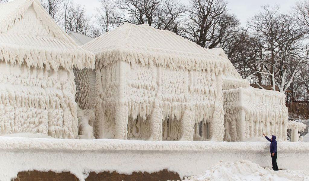 

En person tar bilder av riktigt kalla hus vid strandlinjen Crystal Beach i Fort Erie, Ontario, Kanada, den 28 december. Den stora snöstormen slog ut elektriciteten för tusentals invånare i området. Foto: Cole Burston/AFP via Getty Images                                                                                        