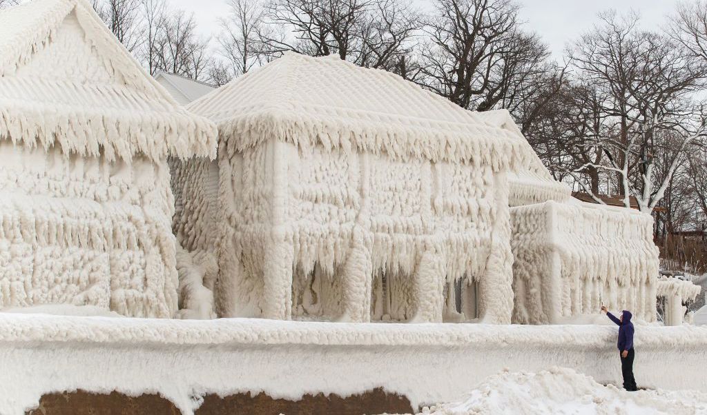 En person tar bilder av riktigt kalla hus vid strandlinjen Crystal Beach i Fort Erie, Ontario, Kanada, den 28 december. Den stora snöstormen slog ut elektriciteten för tusentals invånare i området. Foto: Cole Burston/AFP via Getty Images