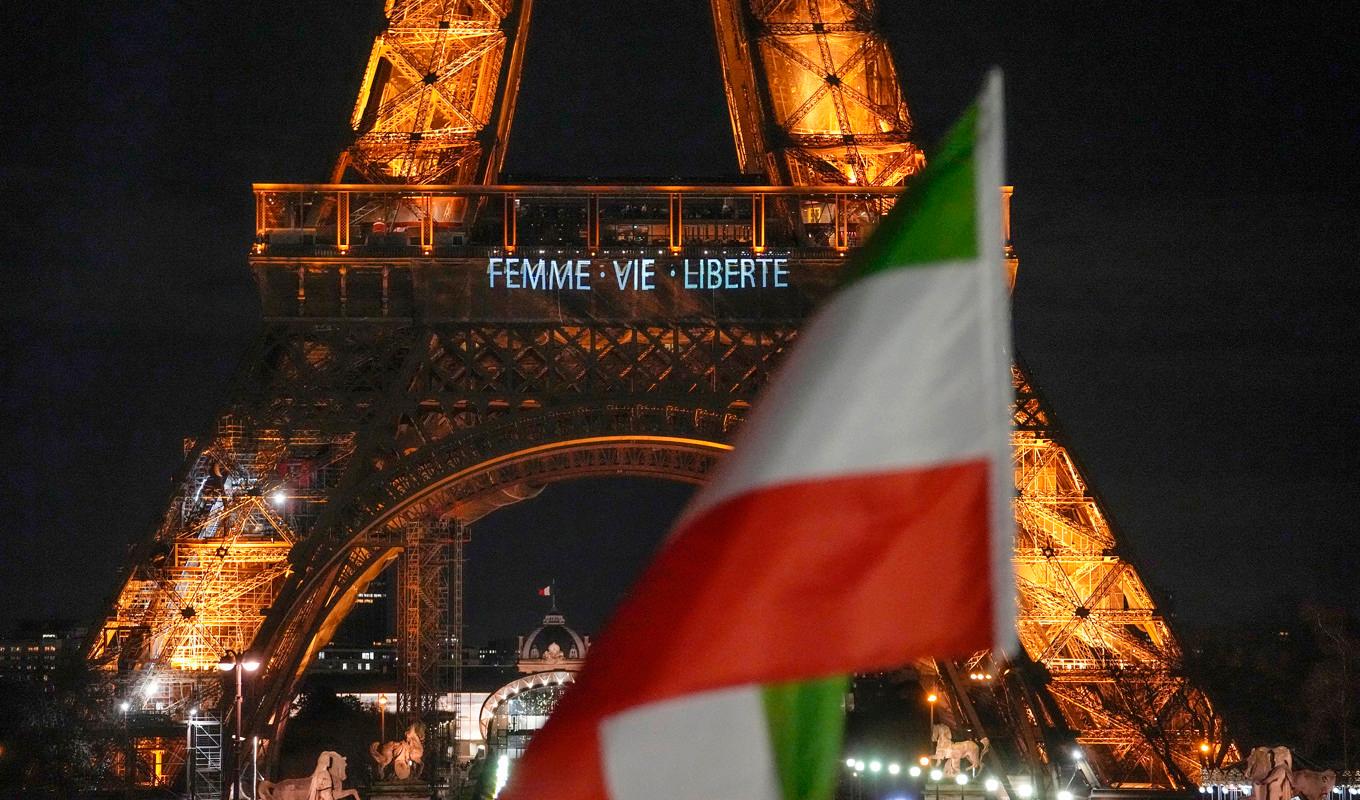 Eiffeltornet lystes under måndagskvällen upp med budskap till stöd för de omfattande regimkritiska protesterna i Iran. Foto: Michel Euler/AP/TT