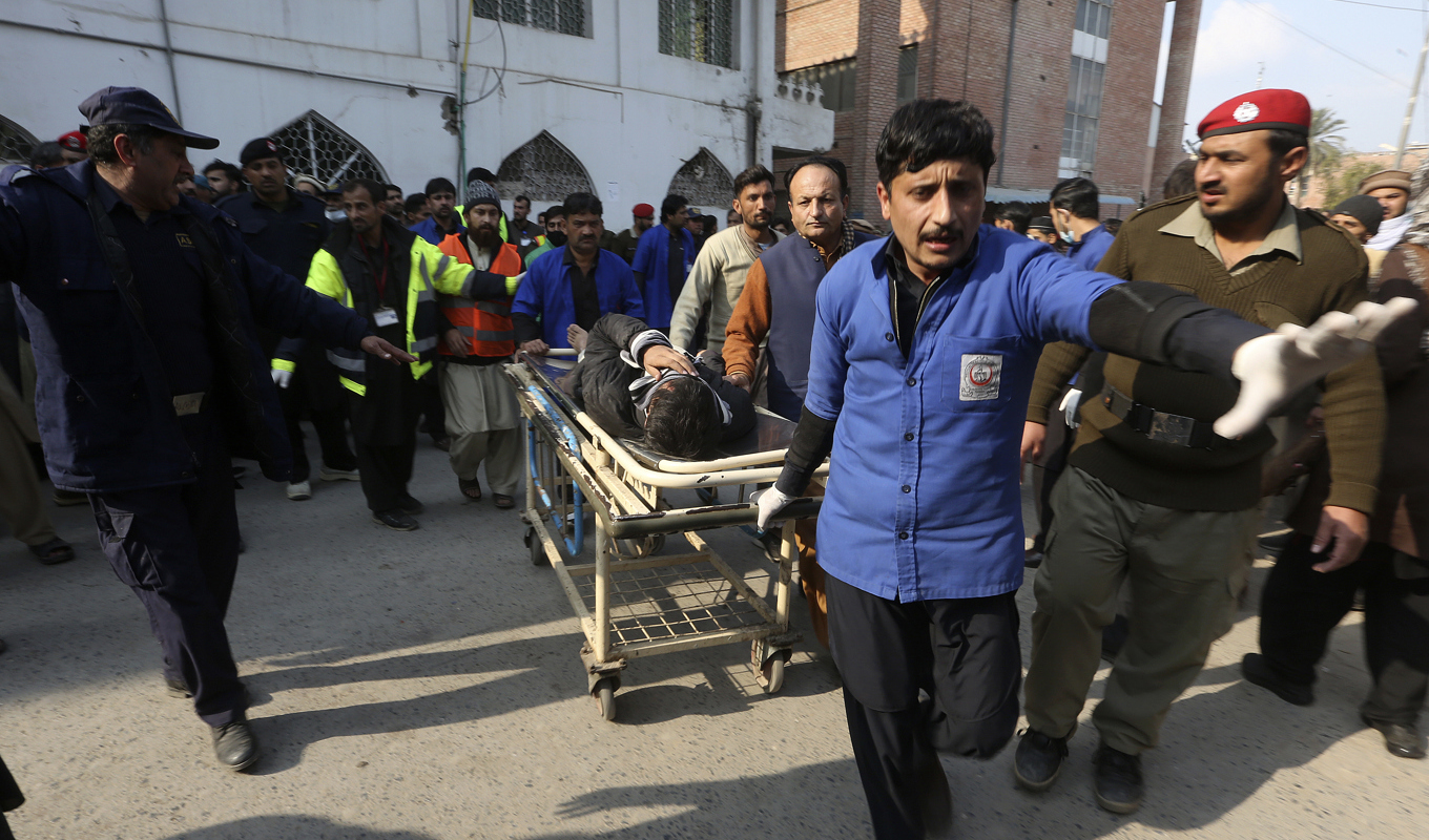 En skadad man förs bort från moskén efter explosionen. Foto: Muhammad Sajjad/AP/TT