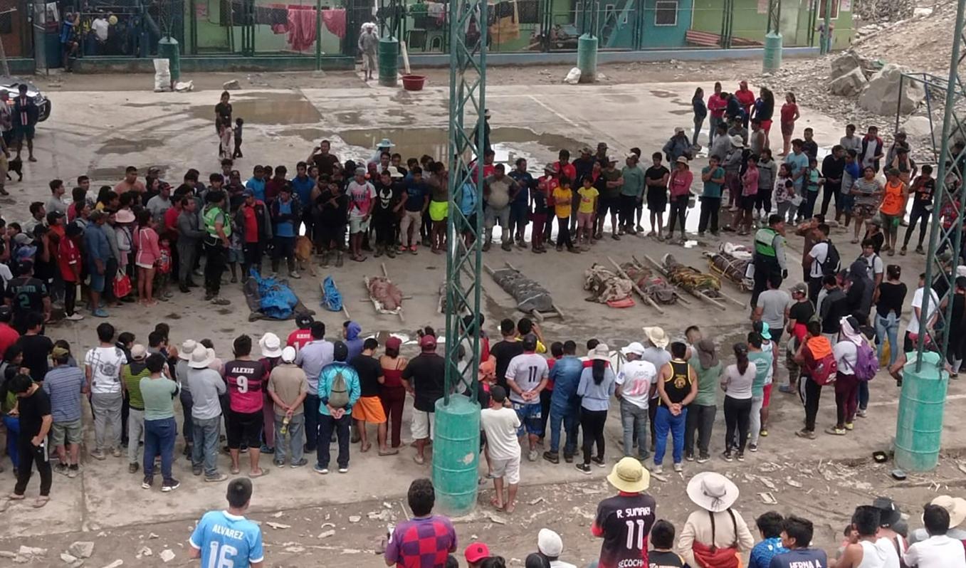 Människor samlas kring bärgade avlidna i staden Camaná. Foto: Ever Chambi/AP/TT