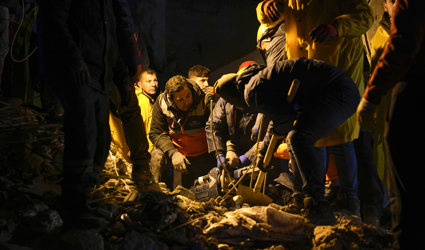 Räddningspersonal söker efter människor i resterna av ett raserad byggnad i Adana i Turkiet. Foto: Khalil Hamra/AP/TT