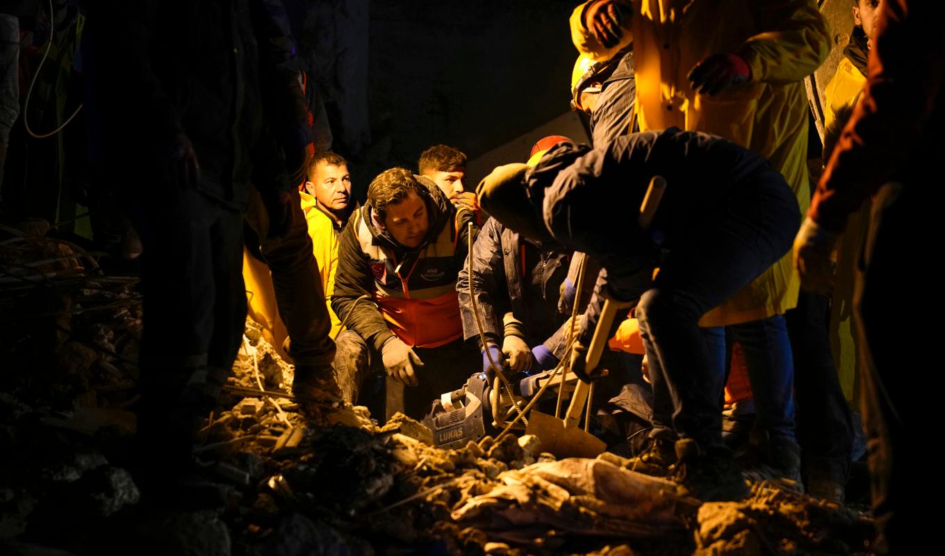 Räddningspersonal söker efter människor i resterna av ett raserad byggnad i Adana i Turkiet. Foto: Khalil Hamra/AP/TT