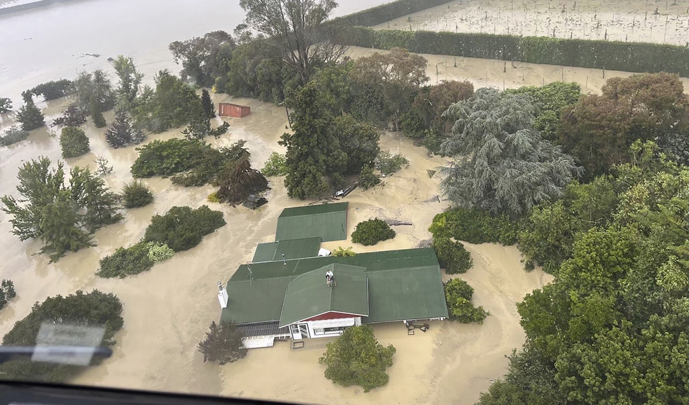 Människor tar skydd på ett tak i väntan på att evakueras. Bild från nyzeeländska försvaret från i onsdags. Foto: Nya Zeelands försvar/AP/TT