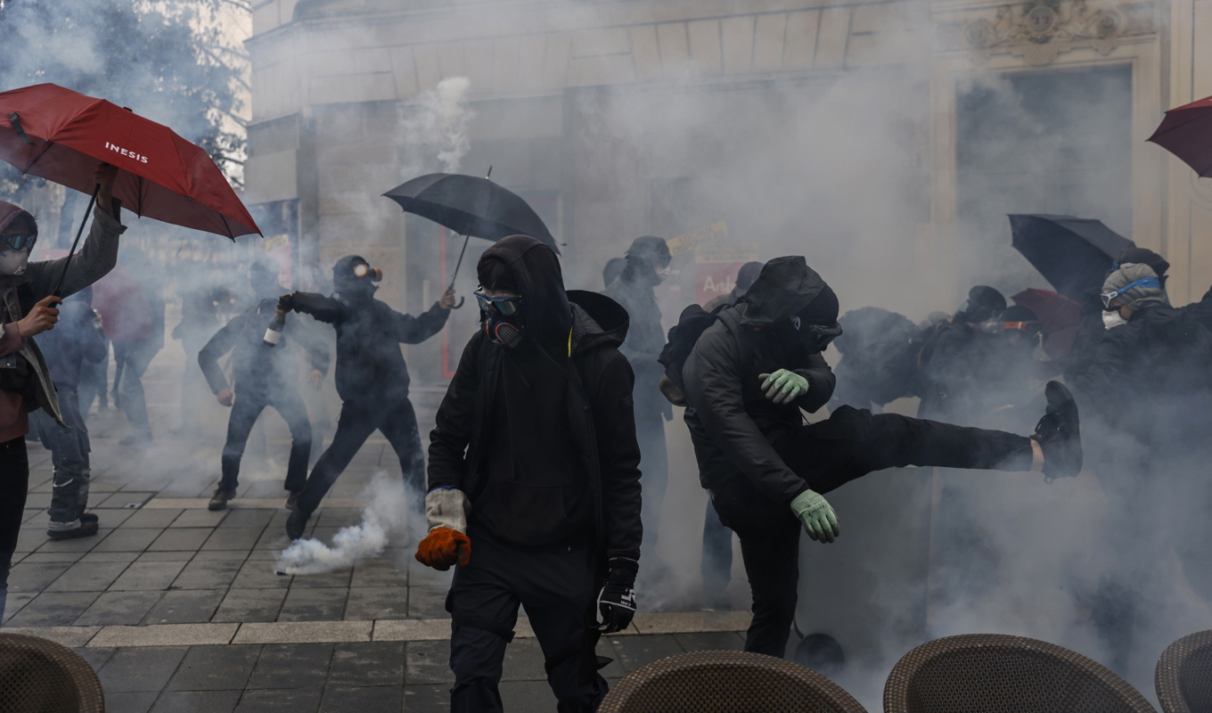 Demonstranter drabbar samman med polis i en dimma av tårgas. Bilden är tagen i Nantes i västra Frankrike. Foto: Jeremias Gonzalez/AP/TT